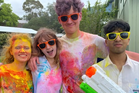Schüler der Hunters Hill High School feiern gemeinsam im Freien umgeben von grüner Vegetation.