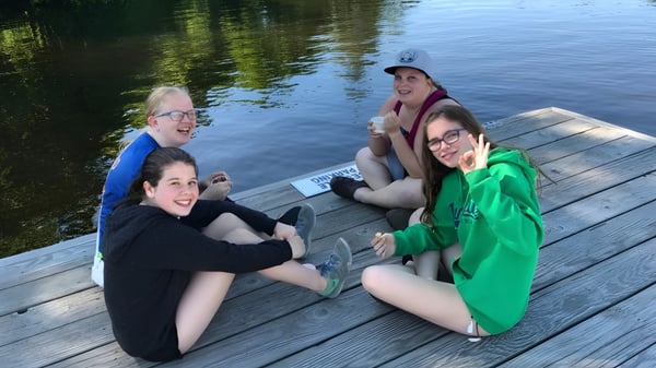 Eine Gruppe junger Frauen sitzt auf einem Holzsteg am See auf dem Gelände der Huntsville High School.
