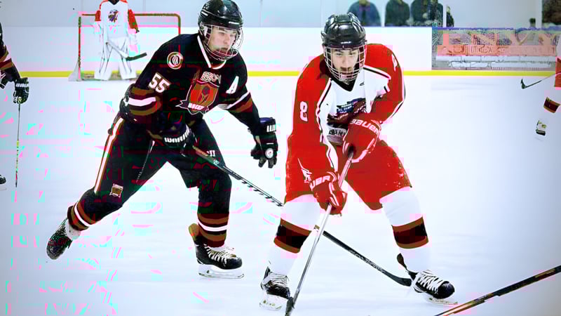 Zwei Hockeyspieler der Huron High School kämpfen in einem Spiel auf dem Eisfeld gegeneinander.