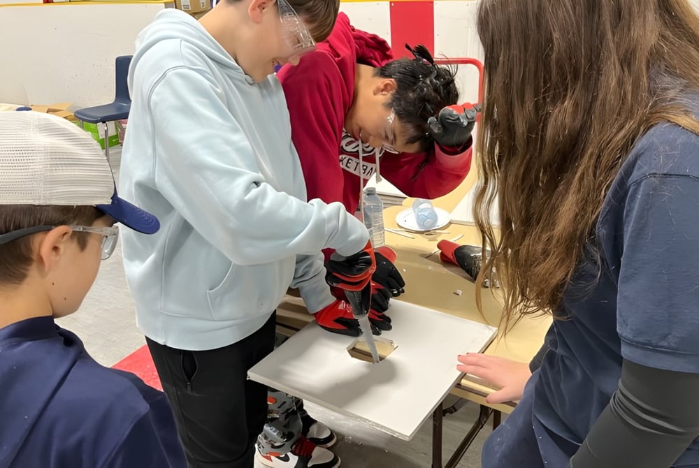Schüler und Lehrkraft im Unterrichtsraum des Huron-Perth Catholic District School Board mit Lernmaterialien im Hintergrund.