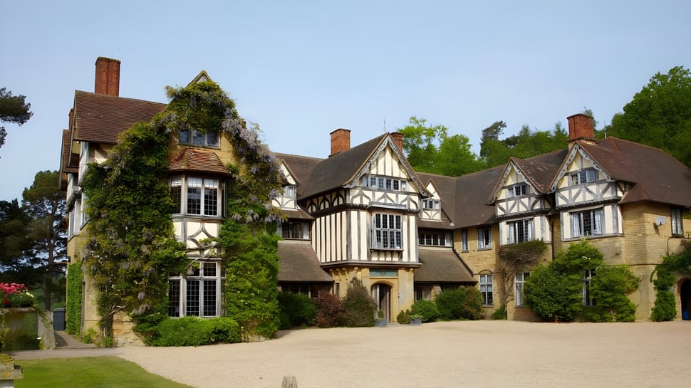 Das Tudor-Stil Herrenhaus auf dem Campus der Hurtwood House ist von üppigem Grün umgeben.