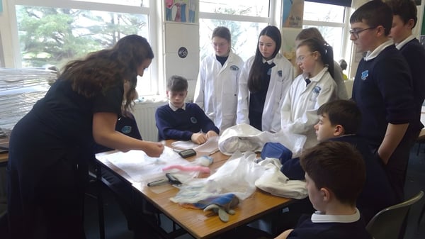Schüler des Iascaigh College untersuchen gemeinsam verschiedene Objekte bei einem Experiment.