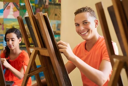 Zwei Schüler der Imagine High Integrated Arts and Technology Secondary School malen im Kunstunterricht auf Leinwänden.