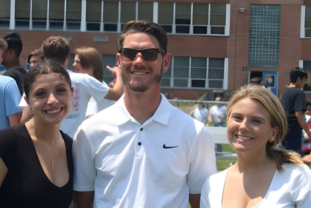 Drei Schüler stehen zusammen im Freien auf dem Campus der Immaculata High School mit einem Gebäude im Hintergrund.