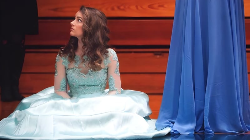 Eine Schülerin der Immaculate Heart Central School steht vor einem blauen Vorhang.