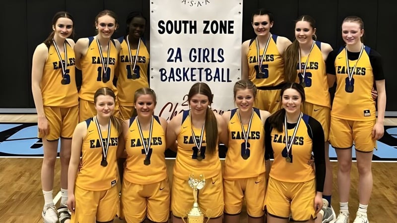 Schülerinnen der Immanuel Christian Secondary School posieren gemeinsam vor dem South Zone 2A Girls Basketball Banner.