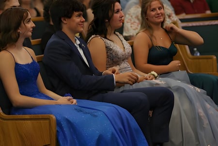 Eine Gruppe von formal gekleideten Personen sitzt bei einer Veranstaltung der Immanuel Christian Secondary School in einem Theater.