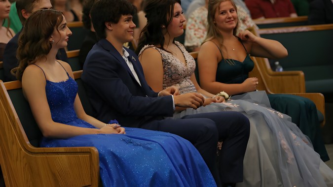Eine Gruppe Schüler der Immanuel Christian Secondary School sitzt bei einer formellen Veranstaltung mit Bühne im Hintergrund.