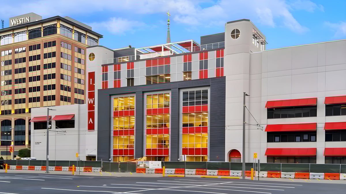 Das moderne mehrstöckige Gebäude mit roter und gelber Fassade auf dem Campus der Incarnate Word Academy ist von Hochhäusern umgeben.