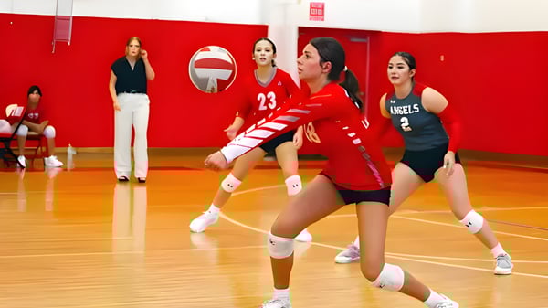 Weibliche Volleyballspielerinnen der Incarnate Word Academy bereiten sich in der Turnhalle auf den nächsten Spielzug vor.