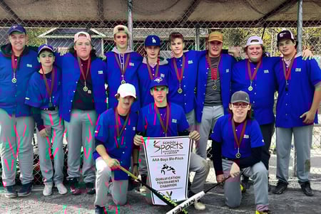 Schüler in blauen Uniformen mit Medaillen stehen gemeinsam vor dem eingezäunten Kids Sports Bereich der Indian River High.