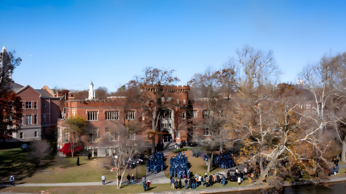 Das historische schlossähnliche Gebäude der Indiana Private Highschool ist vor blauem Himmel mit kahlen Bäumen und Menschen auf dem Weg zu sehen.