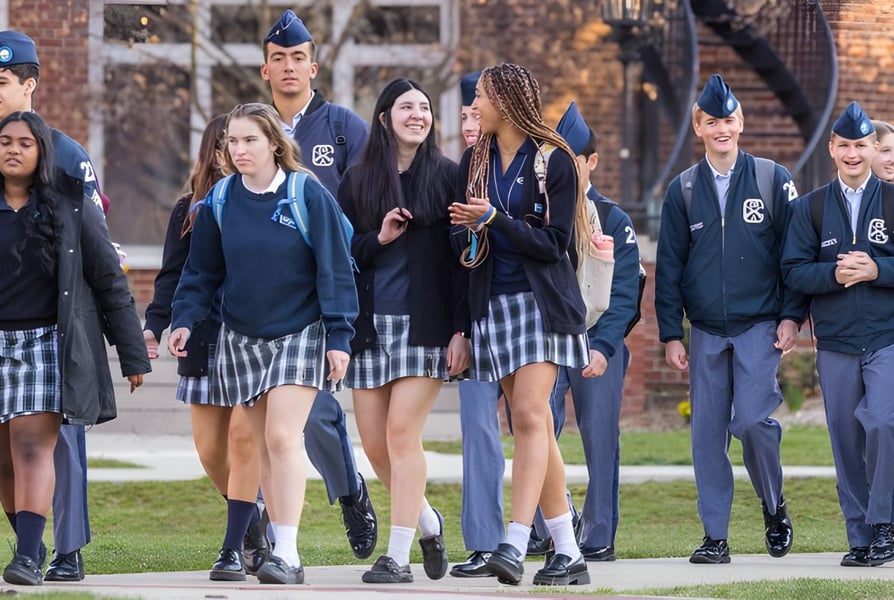 Schüler der Indiana Private Highschool gehen gemeinsam auf dem Campus mit Backsteingebäuden im Hintergrund.