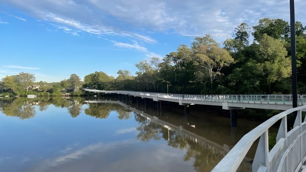 Eine hölzerne Brücke über einem ruhigen Gewässer auf dem Gelände der Indooroopilly State High School.