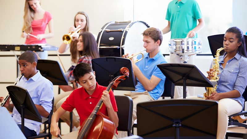 Eine Gruppe Schüler der Indooroopilly State High School spielt verschiedene Musikinstrumente im Klassenraum.