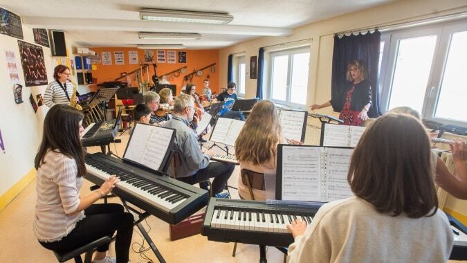 Schüler des Institut Saint-Dominique spielen verschiedene Musikinstrumente und Keyboards im Klassenraum.