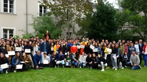 Eine Gruppe von Schülerinnen und Schülern versammelt sich auf dem Rasen vor einem Gebäude der Institution Mongazon.