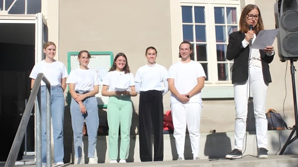 Eine Gruppe von Schülern steht vor dem Gebäude der Institution Mongazon und hält Papiere in der Hand.