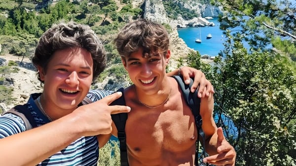 Zwei Schülerinnen der International Bilingual School of Provence machen ein Selfie vor einer grünen Landschaft mit Wasser.