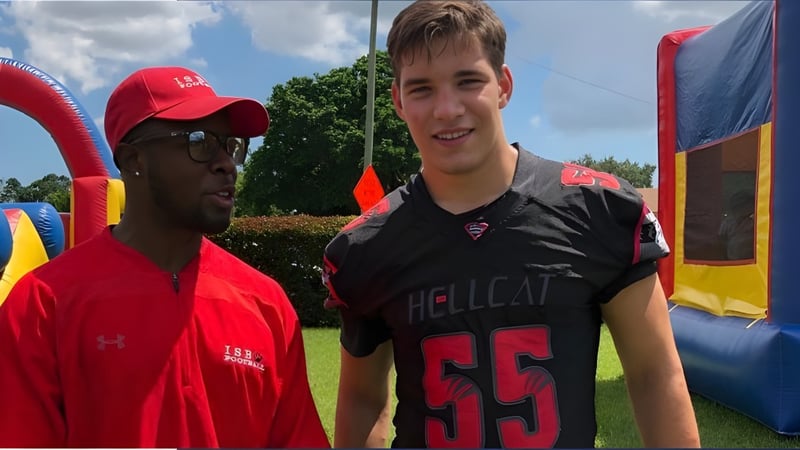 Zwei Schüler der International School of Broward stehen vor einem bunten aufblasbaren Spielplatz im Freien.