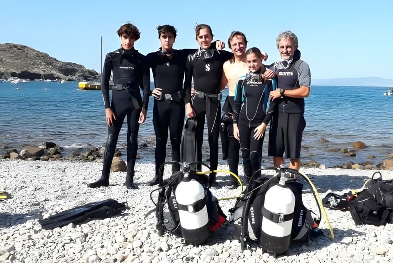 Schueler der International School San Patricio Toledo bereiten sich am felsigen Strand zum Tauchen vor.
