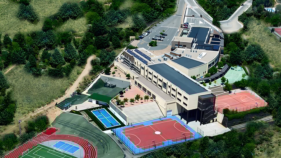 Luftaufnahme des Gebäudekomplexes und der Sportanlagen auf dem Campus der International School San Patricio Toledo.