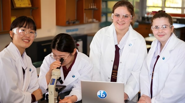 Vier Frauen im weißen Kittel stehen gemeinsam in einem Labor der Ipswich State High School.