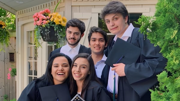 Eine Gruppe von Schülerinnen und Schülern der Iroquois Ridge High School steht in formeller Kleidung in einem Garten mit Blumen und Grünflächen.