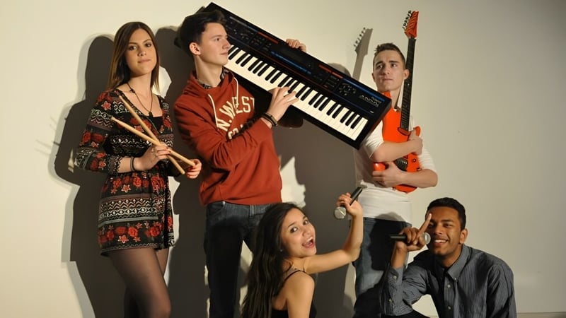 Eine Gruppe von Schülerinnen und Schülern mit Musikinstrumenten auf dem Campus des Itchen Sixth Form College.