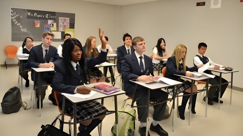 Eine Gruppe Schüler der J. Addison School sitzt in Schuluniformen im Klassenraum mit Lehrmaterialien und pädagogischen Postern.