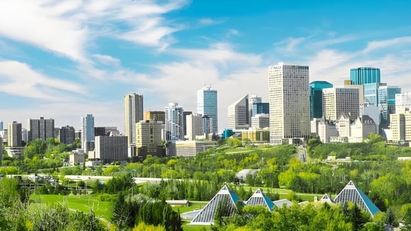 Eine lebendige Stadtszene mit hohen Wolkenkratzern und viel Grün unter blauem Himmel in der Nähe der J. Percy Page High School.