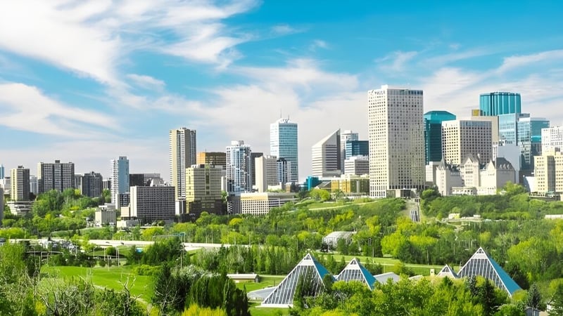 Eine lebendige Stadtszene mit hohen Wolkenkratzern und viel Grün unter blauem Himmel in der Nähe der J. Percy Page High School.