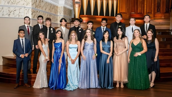 Eine Gruppe formal gekleideter Personen steht vor einer großen Orgel im prunkvollen Innenraum des James Hargest College.