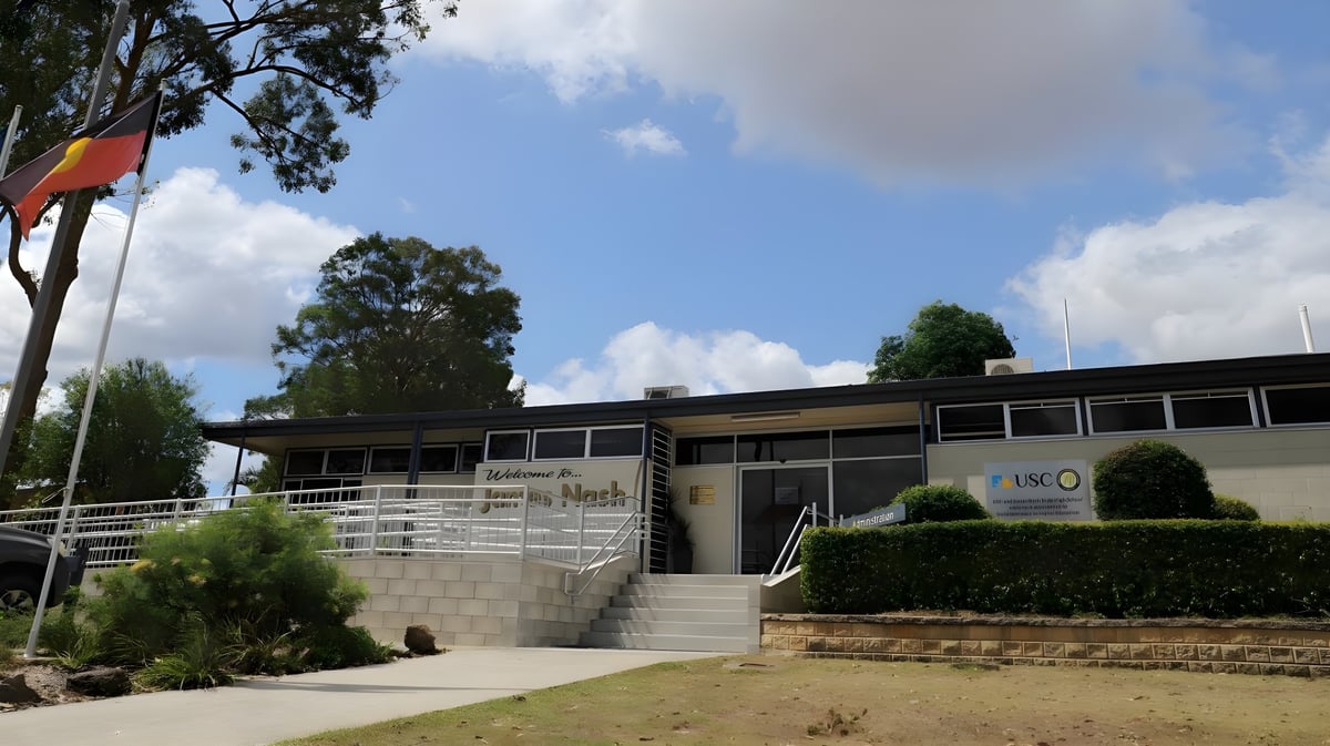 Das moderne zweistöckige Gebäude der James Nash State High School mit großen Fenstern und begrüntem Eingang.