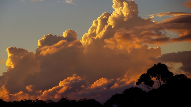 Ein dramatischer Himmel mit golden leuchtenden Wolken über einer Silhouette ist über dem Gelände der James Nash State High School zu sehen.