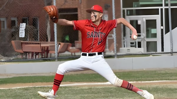 Ein Baseballspieler in rotem Saints-Uniform steht auf einem Baseballfeld bei Jeffco Public Schools.