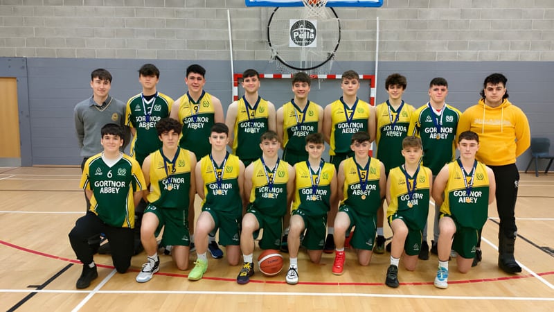 Eine Gruppe von Schülern der Jesus and Mary Secondary School posiert in der Turnhalle vor einem Basketballkorb.