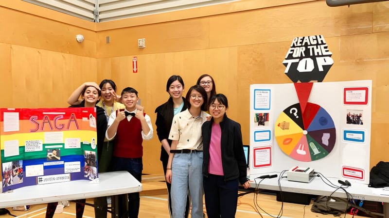 Eine Gruppe von Schülerinnen steht vor einem Anschlagbrett auf dem Campus der J.N. Burnett Secondary School.