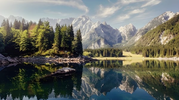 Der alpine See mit schneebedeckten Bergen und Nadelwäldern spiegelt die Landschaft am John Abbott College wider.