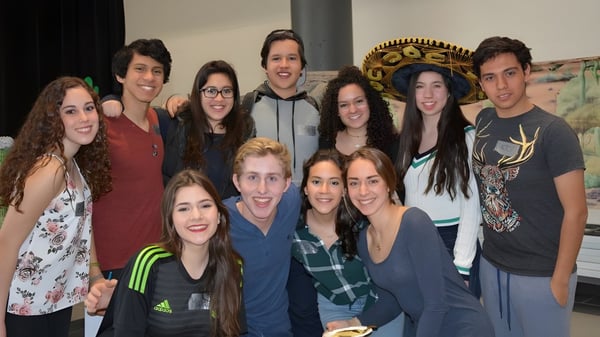 Eine Gruppe Schülerinnen und Schüler posiert zusammen in einem Raum auf dem Campus des John Abbott College.