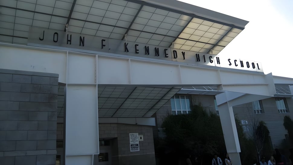 Das moderne Hauptgebäude der John F. Kennedy High School mit dem Schriftzug an der Fassade.