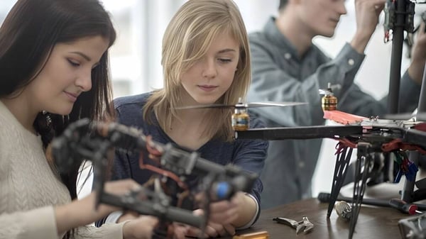 Drei Schüler arbeiten gemeinsam an einem mechanischen Gerät in der Werkstatt des John F. Ross Collegiate Vocational Institute.