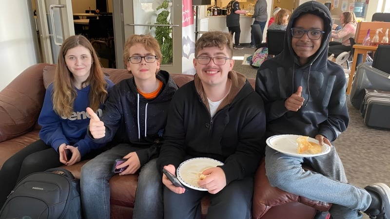 Vier Schülerinnen und Schüler der John Maland High School sitzen zusammen auf einer Couch in einem Café.