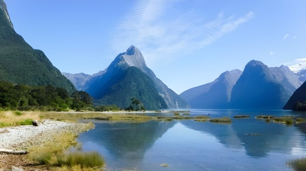 Ein ruhiger See mit schneebedeckten Bergen im Hintergrund, aufgenommen in der Nähe des John Paul College.
