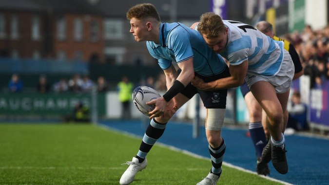 Zwei Rugbyspieler kämpfen um den Ball bei einem Spiel auf dem Spielfeld der John Scottus Secondary School.