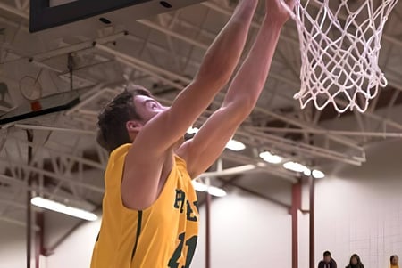 Ein Schüler des John Taylor Collegiate macht einen Dunk im Basketballtraining in der Halle.
