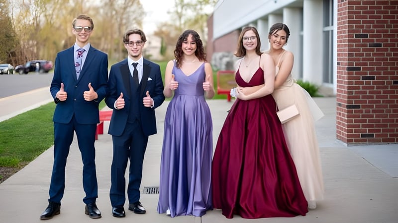 Eine Gruppe von Personen steht auf dem Campus der JSerra Catholic High School vor einem Backsteingebäude.