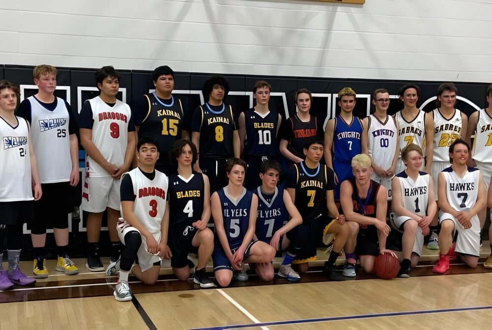 Eine Gruppe von Basketballspielern posiert gemeinsam auf dem Spielfeld der J.T. Foster High School.