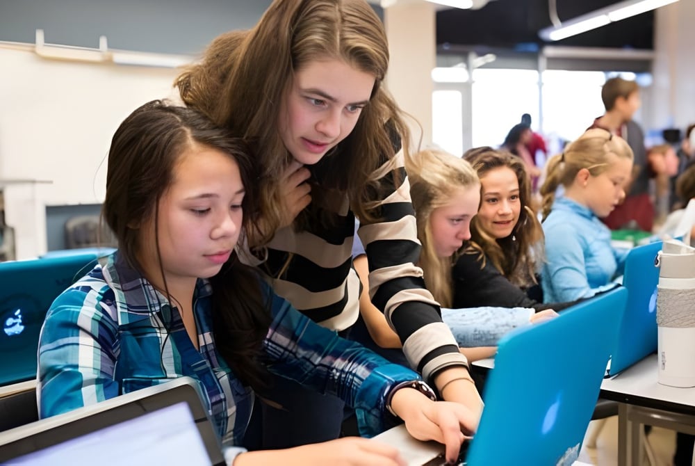 Schüler der Jules Verne School Vancouver arbeiten gemeinsam an Computern im Klassenraum.