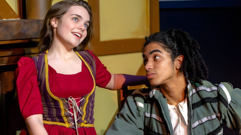 Zwei Schülerinnen und Schüler der Justin Siena High School unterhalten sich und lächeln in einem Raum mit Holzwänden.